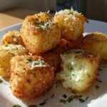 A pile of golden brown Air Fryer Crispy Garlic Parmesan Potato Cubes topped with cheese and parsley.