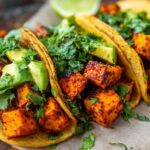 Close-up of Air Fryer Crispy Sweet Potato Tacos filled with seasoned sweet potato cubes, avocado slices, and fresh cilantro.