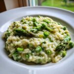 Close-up of a bowl of Easy Creamy Asparagus Risotto topped with whole asparagus tips.
