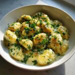 Close-up of Easy One-Pan Creamy Garlic Butter Gnocchi covered in a rich sauce and fresh parsley.
