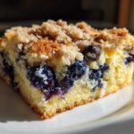 Close-up of a square slice of Easy Sheet Pan Blueberry Streusel Pancake with juicy blueberries and crumb topping.