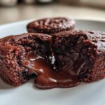 Close-up of a Gluten-Free Chocolate Lava Brownie Cup broken open, showing rich, molten chocolate flowing out.