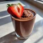 A thick, rich Keto Chocolate Strawberry Smoothie topped with a fresh, halved strawberry.