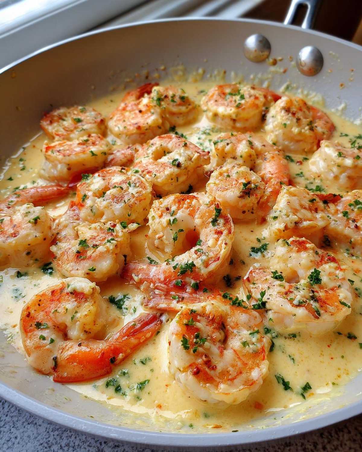 Close-up of plump shrimp simmering in a rich, creamy garlic sauce, garnished with fresh parsley; Keto Creamy Garlic Shrimp Skillet.