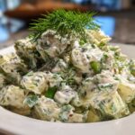 A generous serving of Keto Creamy Herb Deviled Egg Salad, topped with fresh dill, in a white bowl.