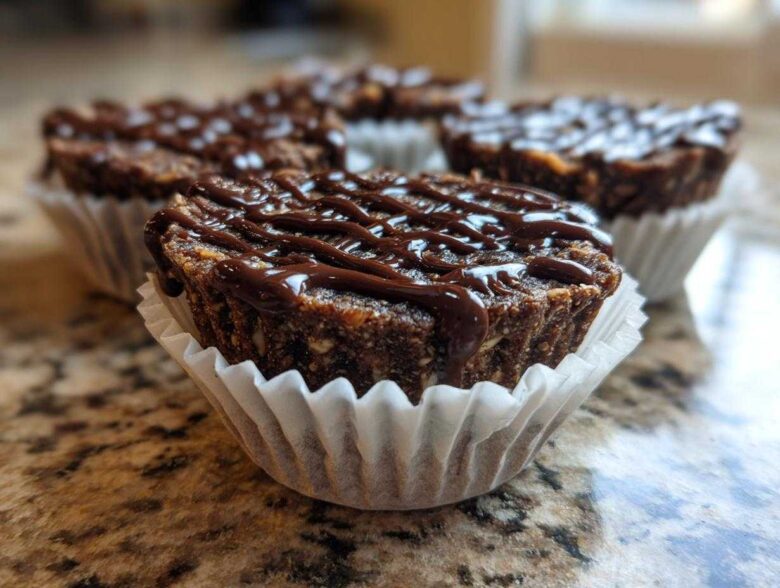 Close-up of a No-Bake Chocolate Coconut Protein Cups drizzled with melted chocolate, sitting in a white paper liner.