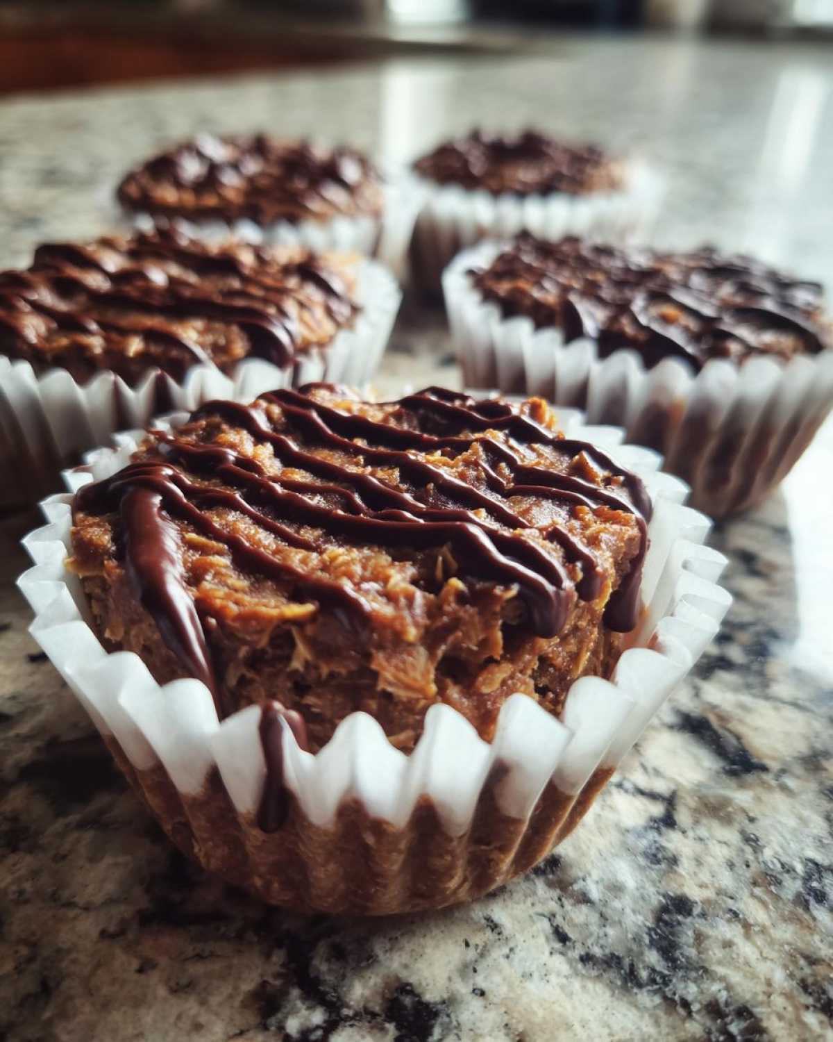 Close-up of a No-Bake Chocolate Coconut Protein Cup topped with a dark chocolate drizzle.