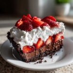 A decadent slice of No-Bake Strawberry Chocolate Pudding Pie with chocolate crust, pudding, and whipped cream topping.