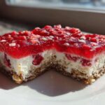 Two squares of No-Bake Strawberry Pretzel Dessert Bars showing the pretzel crust, cream cheese layer, and bright red strawberry gelatin topping.