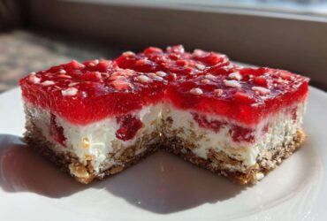 Two squares of No-Bake Strawberry Pretzel Dessert Bars showing the pretzel crust, cream cheese layer, and bright red strawberry gelatin topping.