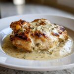 Close-up of a perfectly seared chicken breast topped with creamy coconut lime sauce, ready to eat.