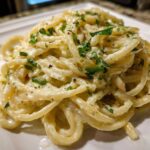 Close-up of a serving of One-Pot Creamy White Bean Lemon Pasta, coated in a rich sauce and topped with fresh parsley.