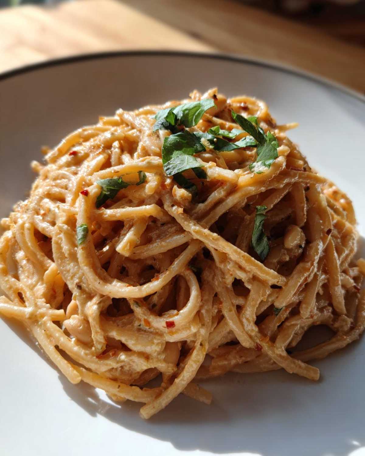 Close-up of One-Pot Creamy White Bean Lemon Pasta tossed in a rich sauce and garnished with fresh herbs.