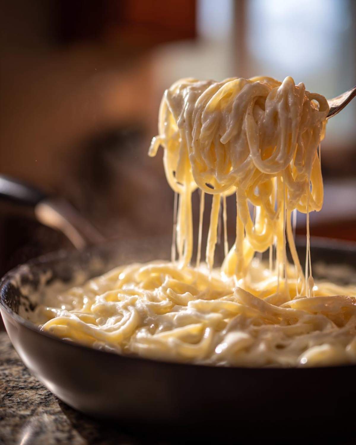 A fork lifting steaming spaghetti coated in thick, creamy Easy Cottage Cheese Alfredo Sauce from a dark pan.