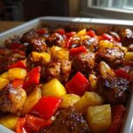 Close-up of baked chicken pieces coated in a rich glaze mixed with chunks of pineapple and red bell peppers, ready for Hawaiian Chicken Pineapple Teriyaki Glaze.
